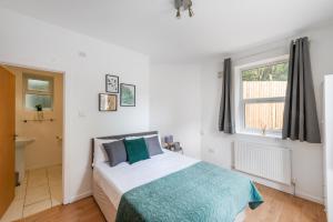 1 dormitorio con cama y ventana en Apartments in Brixton next door to Brockwell Park en Londres
