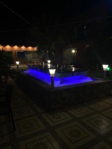 فندق ادوماتو ADOMATo HOTEl في Dawmat al Jandal: حمام سباحة مع إضاءة زرقاء في الليل