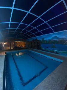 uma piscina com iluminação azul num edifício em فندق ادوماتو ADOMATo HOTEl em Dawmat al Jandal