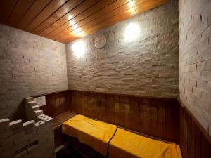 泉佐野市にある関空温泉ホテルガーデンパレスのレンガの壁にベッドが備わる小さな客室です。