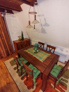 Vila Sreća - Kolašin في كولاسين: غرفة طعام مع طاولة وكراسي خشبية