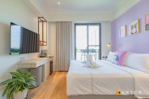 una camera da letto con un grande letto bianco e una scrivania di Mika BnB a Shih-t'ou-wei