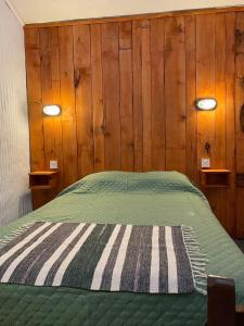 ecohoteltdf في ريو غراندي: سرير في غرفة بجدران خشبية