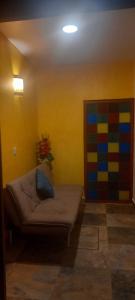 a living room with a couch and a colorful wall at Casa Esmeralda Hotel in Oaxaca City
