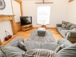 a living room with a couch and a tv at Flat Above 27 in Bishop Auckland