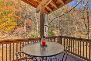 a table and chairs on a porch with a view at Creekside Retreat with Deck, 18 Miles to Wolf Ridge in Weaverville