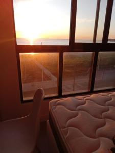 a bedroom with a bed and a view of the ocean at Apto Studio Square 990 - Vista Mar in Navegantes