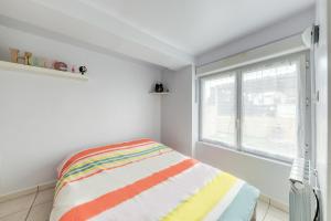 Cette chambre blanche dispose d'un lit et d'une fenêtre. dans l'établissement appartement tout équipé avec terrasse et parking privé, à Brétigny-sur-Orge
