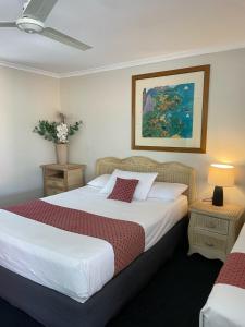 a bedroom with two beds and a painting on the wall at Kyamba Court Motel in Mooloolaba