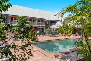 a pool in front of a resort with palm trees at Byron Central Apartments in Byron Bay +49 photos