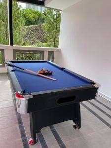 a pool table with two cuesticks on top of it at 60PAX 9BR Villa Kids Swimming Pool, KTV, BBQ n Pool Tables near SPICE Arena Penang 9800 SQFT in Bayan Lepas