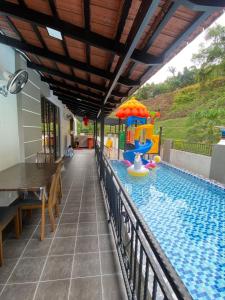a swimming pool with a table and a play structure at 60PAX 9BR Villa Kids Swimming Pool, KTV, BBQ n Pool Tables near SPICE Arena Penang 9800 SQFT in Bayan Lepas