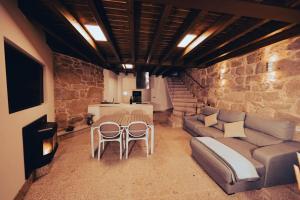 a living room with a couch and a table and chairs at Casa Rural Vilar de Flores in Ourense