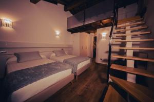 1 dormitorio con 2 camas y escalera en Casa Rural Vilar de Flores en Ourense