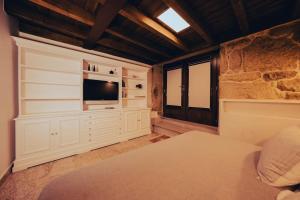 a bedroom with a bed and a television on a wall at Casa Rural Vilar de Flores in Ourense