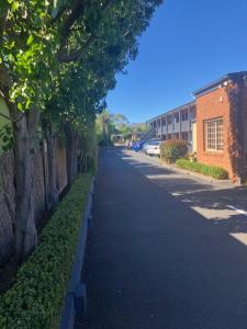 una calle vacía con árboles al lado de un edificio en Admiral Motor Inn, en Rosebud