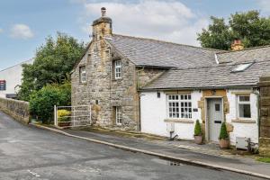 an old stone house on the side of a street at Bridge End Cottage in Stainforth
