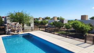 a swimming pool in front of a building at Morada del Cóndor - Cabañas Serranas in Merlo