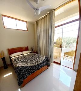 a bedroom with a bed and a large window at Casa Entre Rocas y Veleros in Los Órganos