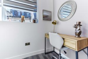 a desk and a chair in a room with a mirror at Comfy and Contemporary One Bedroom Flat in London