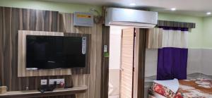 a room with a tv and a bed in a room at LN BEACH Homestay in Puri
