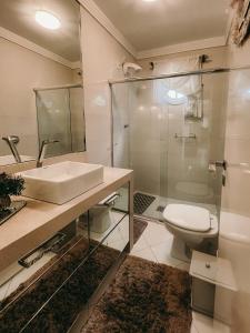 y baño con aseo, lavabo y ducha. en Casa confortável em local tranquilo. en Rodeio