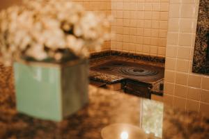 um balcão de cozinha com um fogão e um vaso de flores em Casa confortável em local tranquilo. em Rodeio