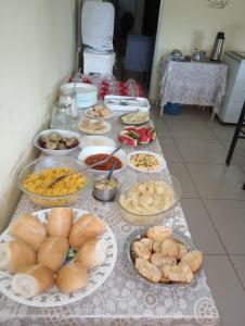 ein Tisch mit vielen Teller Essen drauf in der Unterkunft POUSADA LELÊ CONVENÇÕES in Recife