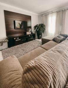 sala de estar con sofá y TV de pantalla plana en Casa confortável em local tranquilo. en Rodeio