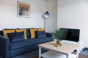 Sala de estar con sofá azul y mesa de centro en Victoria Cottage en Cannock