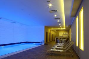 a swimming pool in a hotel with chairs and a table at Luxor Garden Hotel in Kocaeli