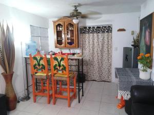 een keuken met 2 oranje stoelen en een tafel met bij ¡Confortable y Privado! - Ubicado en Av. principal in Guadalajara