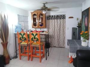 a kitchen with two orange chairs and a table with at ¡Confortable y Privado! - Ubicado en Av. principal in Guadalajara