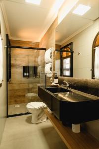 a bathroom with a sink and a toilet at Malbec Casa Hotel in Bento Gonçalves