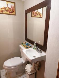 a bathroom with a toilet and a sink and a mirror at ¡Confortable y Privado! - Ubicado en Av. principal in Guadalajara