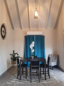 a dining room with a table and chairs and a blue curtain at Quiet Country Living in Saint George