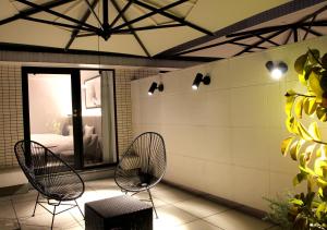 a patio with two chairs and a bed in a room at Oriental Hotel Fukuoka Hakata Station in Fukuoka