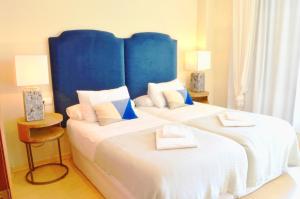a bedroom with two beds with a blue headboard at Penthouse Cathedral Tomas de Ibarra St 6 pax, Parking Optional in Seville