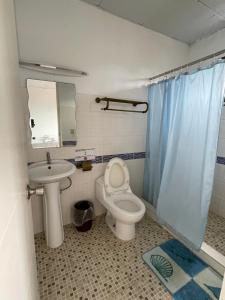 a bathroom with a toilet and a sink and a mirror at Punta Chame Hotal Mi Orquídea in Punta Chame