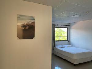 a bedroom with a bed and a picture on the wall at Punta Chame Hotal Mi Orquídea in Punta Chame