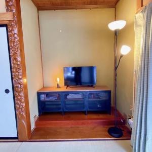 um quarto com uma televisão numa cómoda com um candeeiro em mooi 宮町 em Aizuwakamatsu