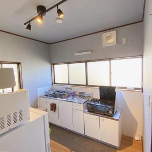 uma cozinha com armários brancos e um lavatório em mooi 宮町 em Aizuwakamatsu