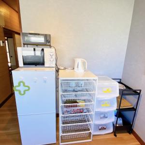 a white refrigerator next to a microwave and a refrigerator at mooi 宮町 in Aizuwakamatsu