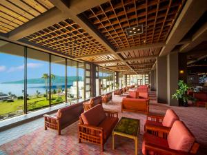 een hotellobby met stoelen, tafels en ramen bij Yukai Resort Premium Hotel Ranpu in Hirado