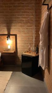 Cette chambre comprend un miroir et une table avec des verres. dans l'établissement Casa Erva Doce Pousada, à Delfinópolis