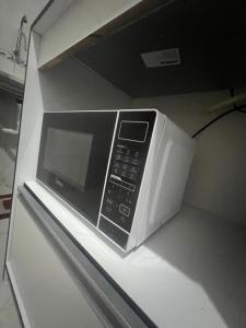 a microwave oven sitting on top of a counter at Ap próximo ao Arco com garagem in Sobral