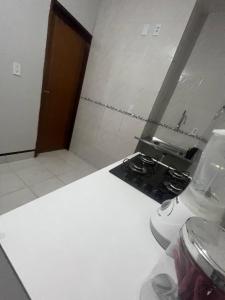 a kitchen with a stove and a white counter top at Ap próximo ao Arco com garagem in Sobral