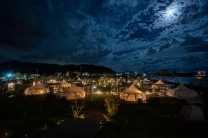 un grupo de tiendas de campaña por la noche con la luna en el cielo en GLAMPREMIER Setouchi en Kanonji