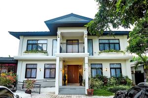 une maison blanche avec une porte d'entrée ouverte dans l'établissement UNWND Boutique Hotel Dumaguete, à Dumaguete