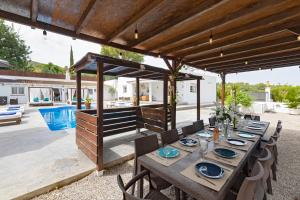 a dining table under a pavilion in a backyard at Villa in Ibiza Town with private pool, sleeps 10 in Sant Rafael de Sa Creu
